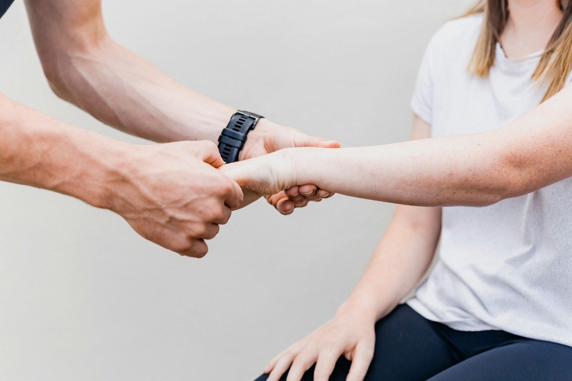 Chiropractor adjusting the wrist joints of a young woman